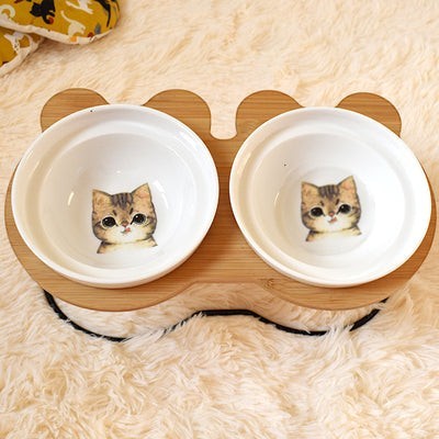 Furlouve double ceramic cat bowls with cute tabby cat face design on a bamboo stand.
