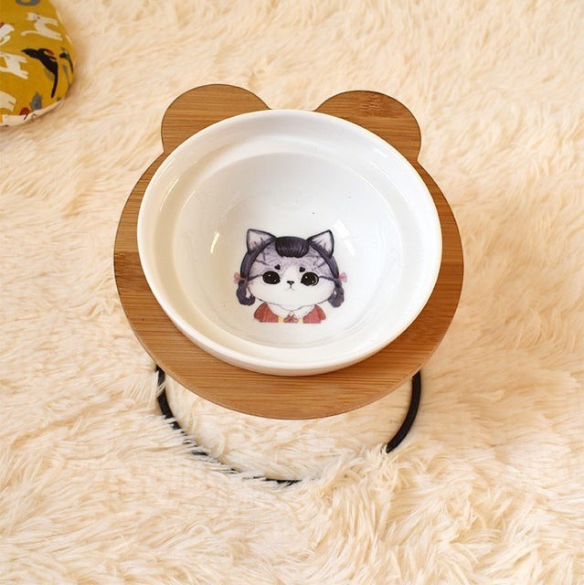 Furlouve Ergonomic Cat Dining Stand with a ceramic bowl featuring a cute cat illustration. Made from bamboo.