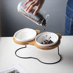 Furlouve Ergonomic Cat Dining Stand with two white ceramic bowls on a wooden base shaped like a Mickey Mouse head.