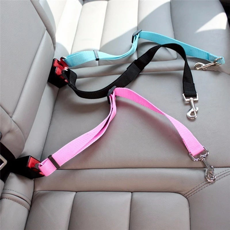 Furlouve adjustable pet car seat belt in pink, black, and sky blue nylon with metal clips, clipped into a car seat.
